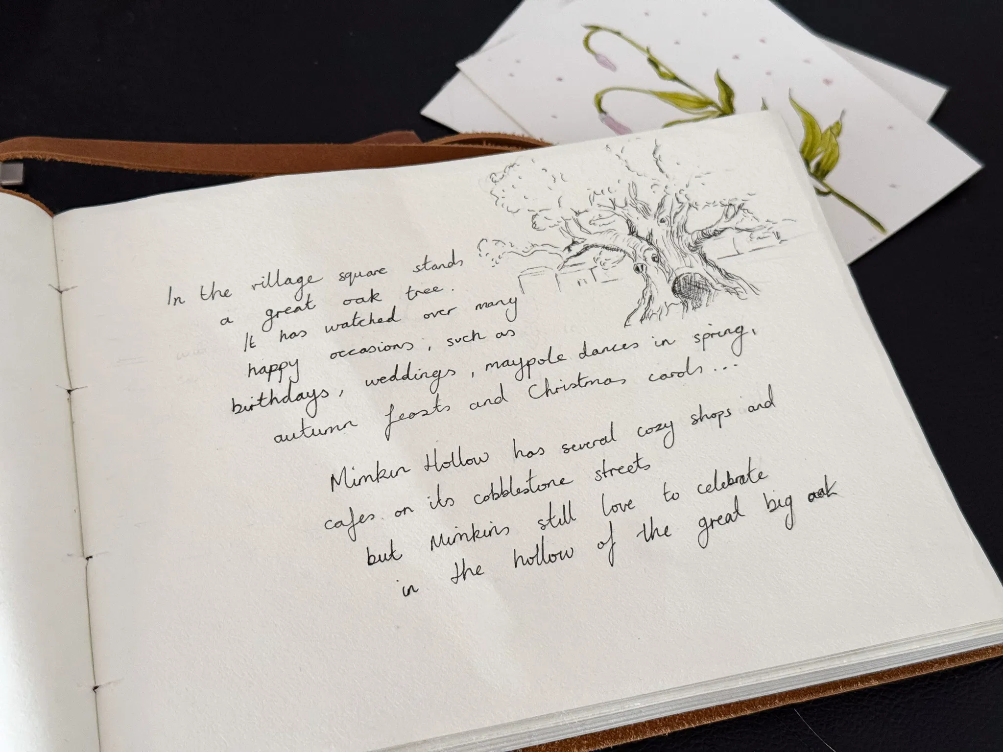 A hand-drawn illustration of the great oak tree in the village square, with a handwritten note about Mimkin Hollow's traditions